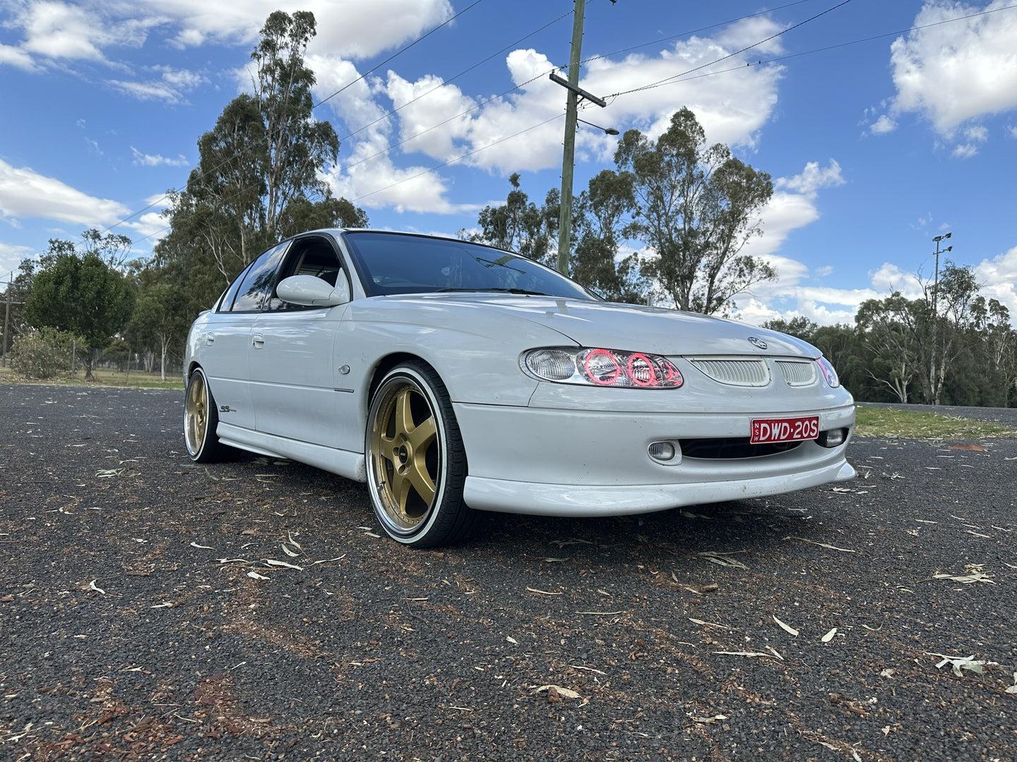 Holden VT Commodore with red angel eye headlights installed by Spectrum